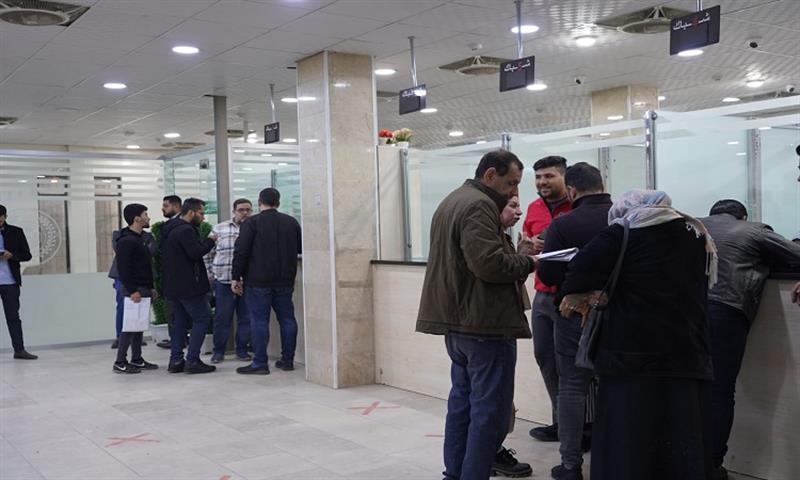 بالصور.. مصرف الرافدين يباشر بيع عملة الدولار للمواطنين لاغراض السفر في بغداد
